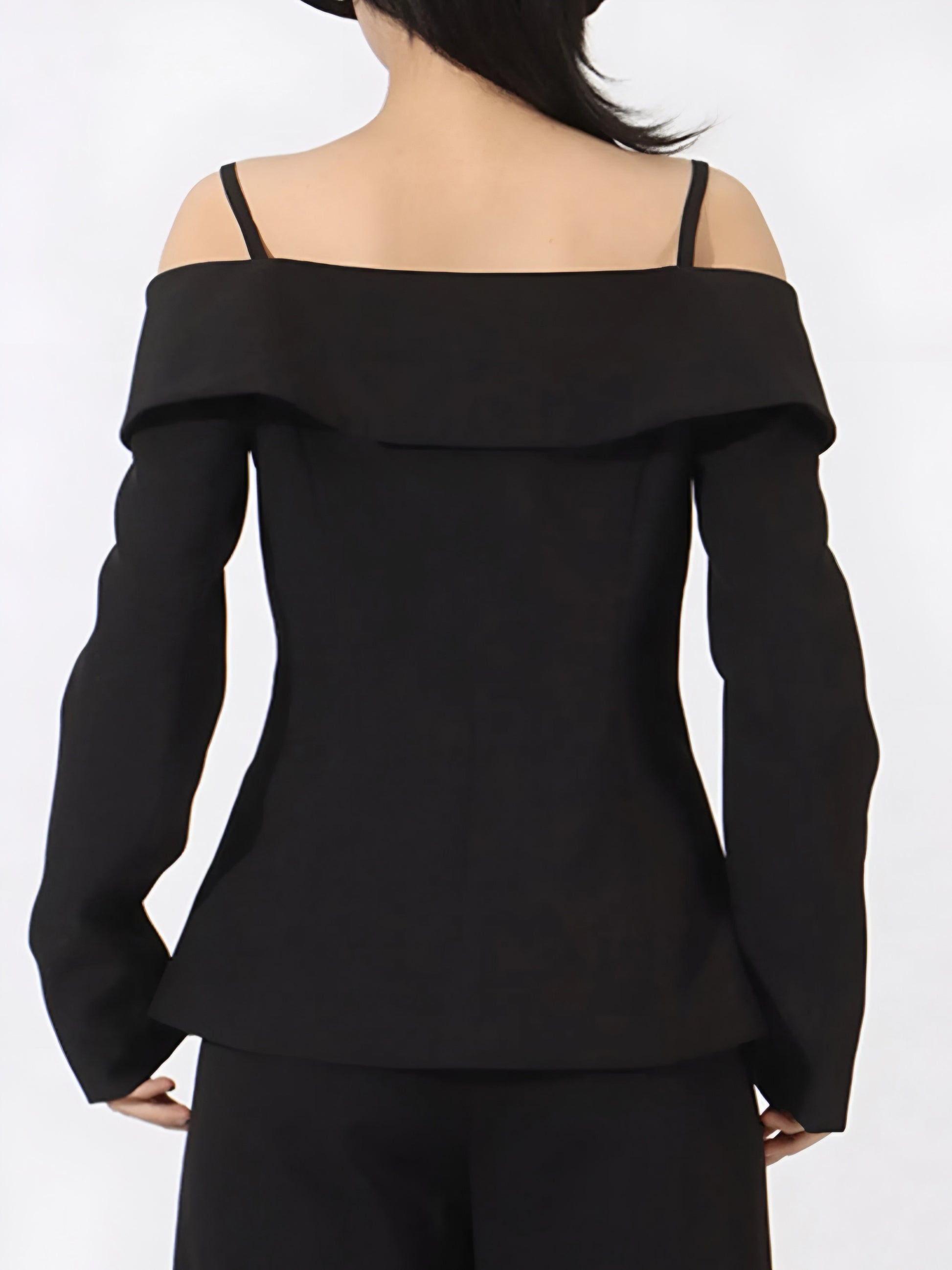 back view of black off-shoulder high fashion style blazer worn by a woman on a white background