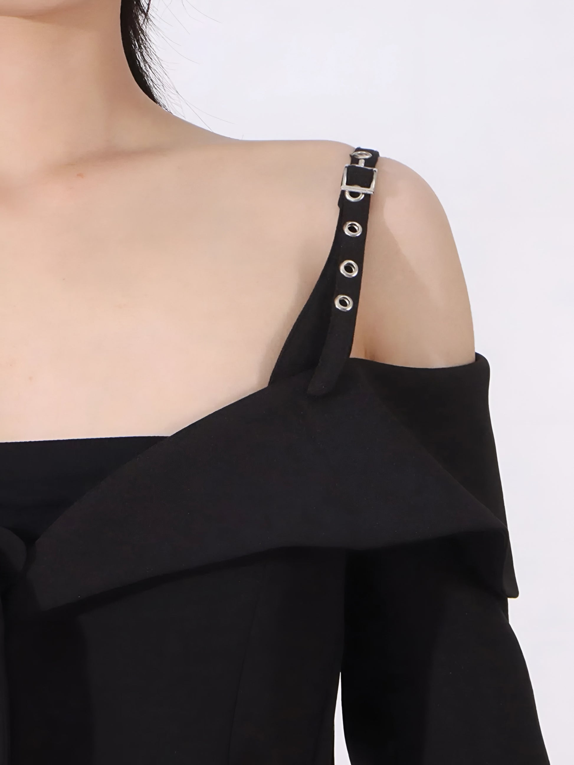 close up of buckle shoulder strap of Black off-shoulder blazer/jacket on a white background