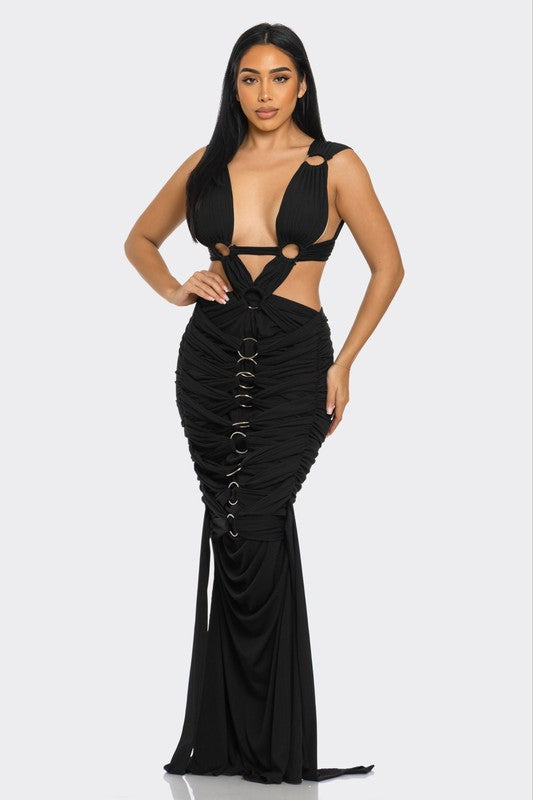 woman wearing a high-fashion evening gown with daring cut-out design with metallic ring embellishments 
