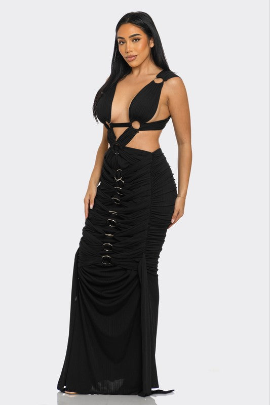Woman wearing a black backless sexy maxi dress with cut-out design on a white background