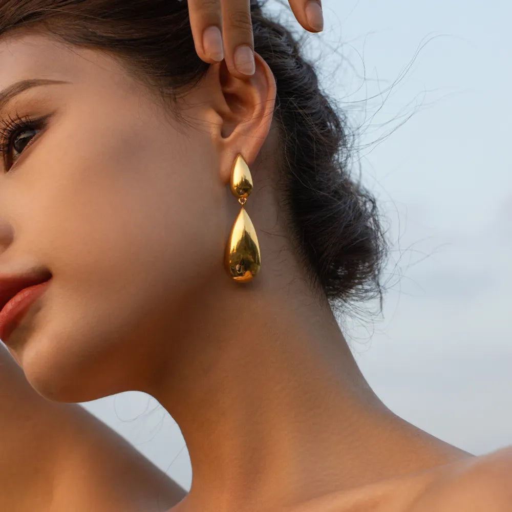 Woman wearing minimalist gold drop earrings with modern design