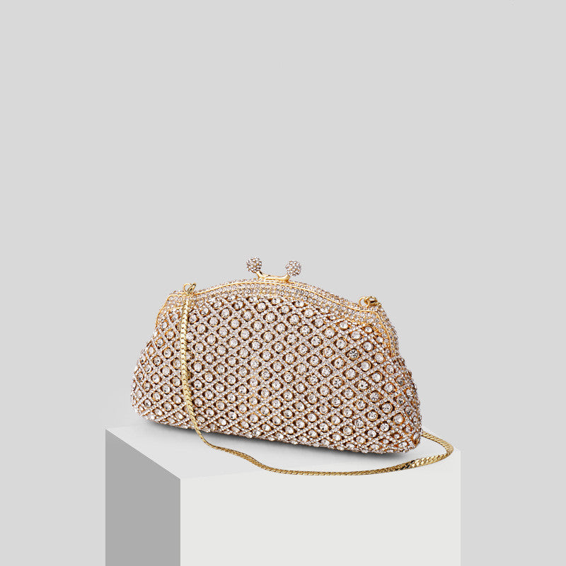 Elegant gold clutch with structured design and clasp top on white column in a white background