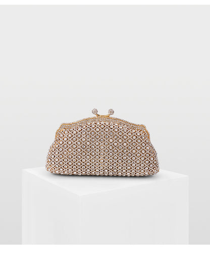 Glamorous gold vintage-style evening bag with rhinestone embellishments on a white backdrop