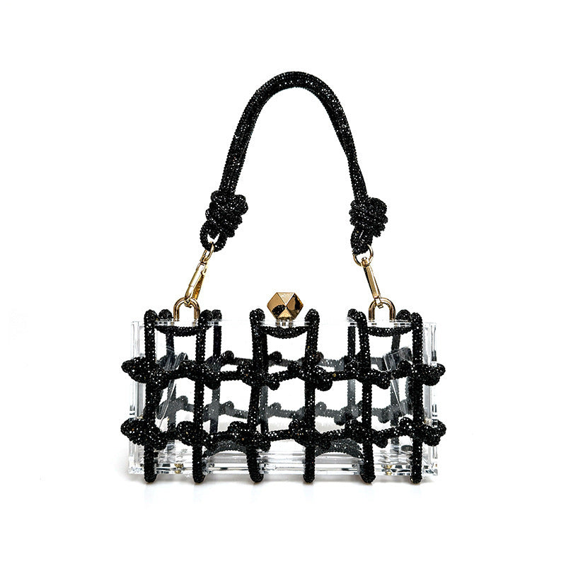 A shiny black rhinestone-encrusted acrylic clear handbag in a square shape with a single handle and gold-colored hardware.