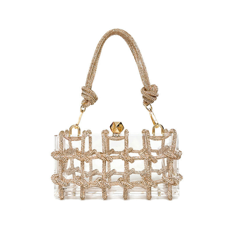 A shiny rhinestone-encrusted champagne acrylic handbag in a square shape with a single handle and gold-colored hardware.