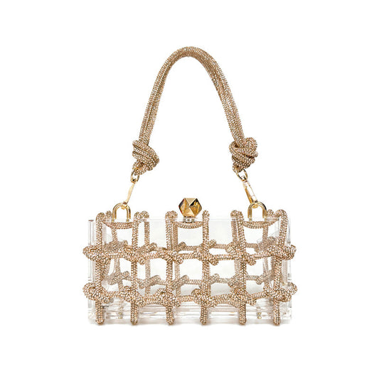 A shiny rhinestone-encrusted champagne acrylic handbag in a square shape with a single handle and gold-colored hardware.