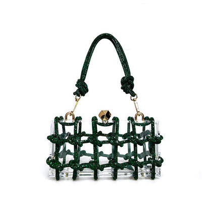 A shiny rhinestone-encrusted dark green acrylic handbag in a square shape with a single handle and gold-colored hardware.