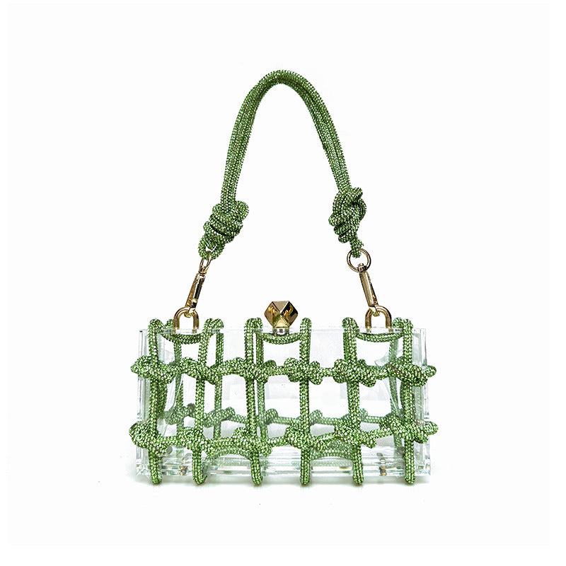 A shiny rhinestone-encrusted light green acrylic handbag in a square shape with a single handle and gold-colored hardware.
