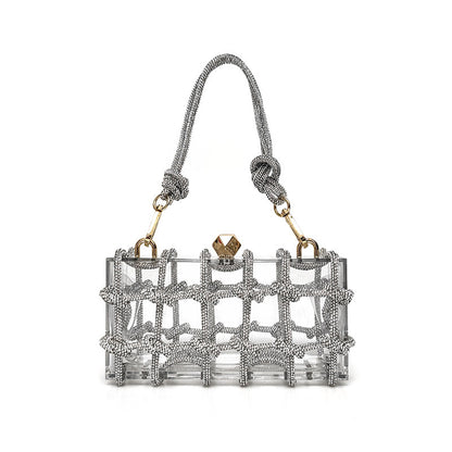 A shiny silver rhinestone-encrusted acrylic clear handbag in a square shape with a single handle and gold-colored hardware.