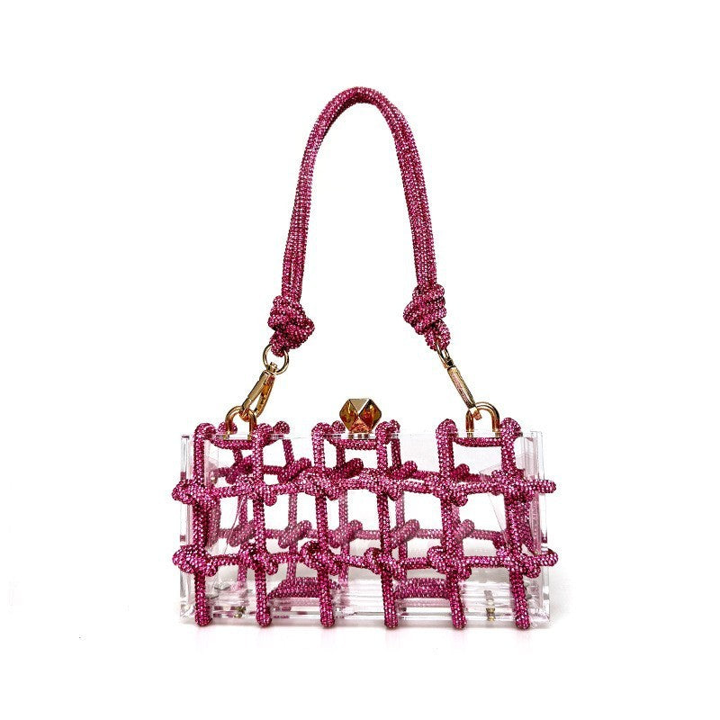 A shiny pink rhinestone-encrusted acrylic clear handbag in a square shape with a single shoulder strap and gold-colored hardware.