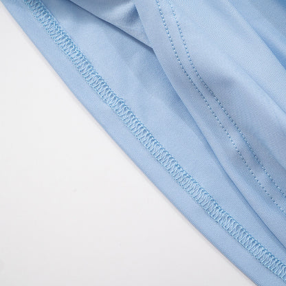 Close-up of hem stitching for light blue  mesh one shoulder top with a white background