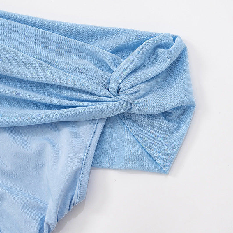close up of knot on Light blue one shoulder mesh with a knot on a white background