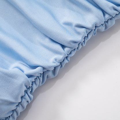 Close-up of light blue mesh one shoulder top  with scrunched edges on a white background