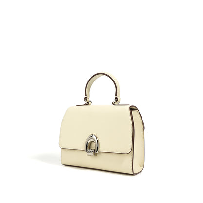 angle view of ivory white colored handbag with a shell shape, made from genuine leather, featuring a sandwich pocket design and a single shoulder strap.