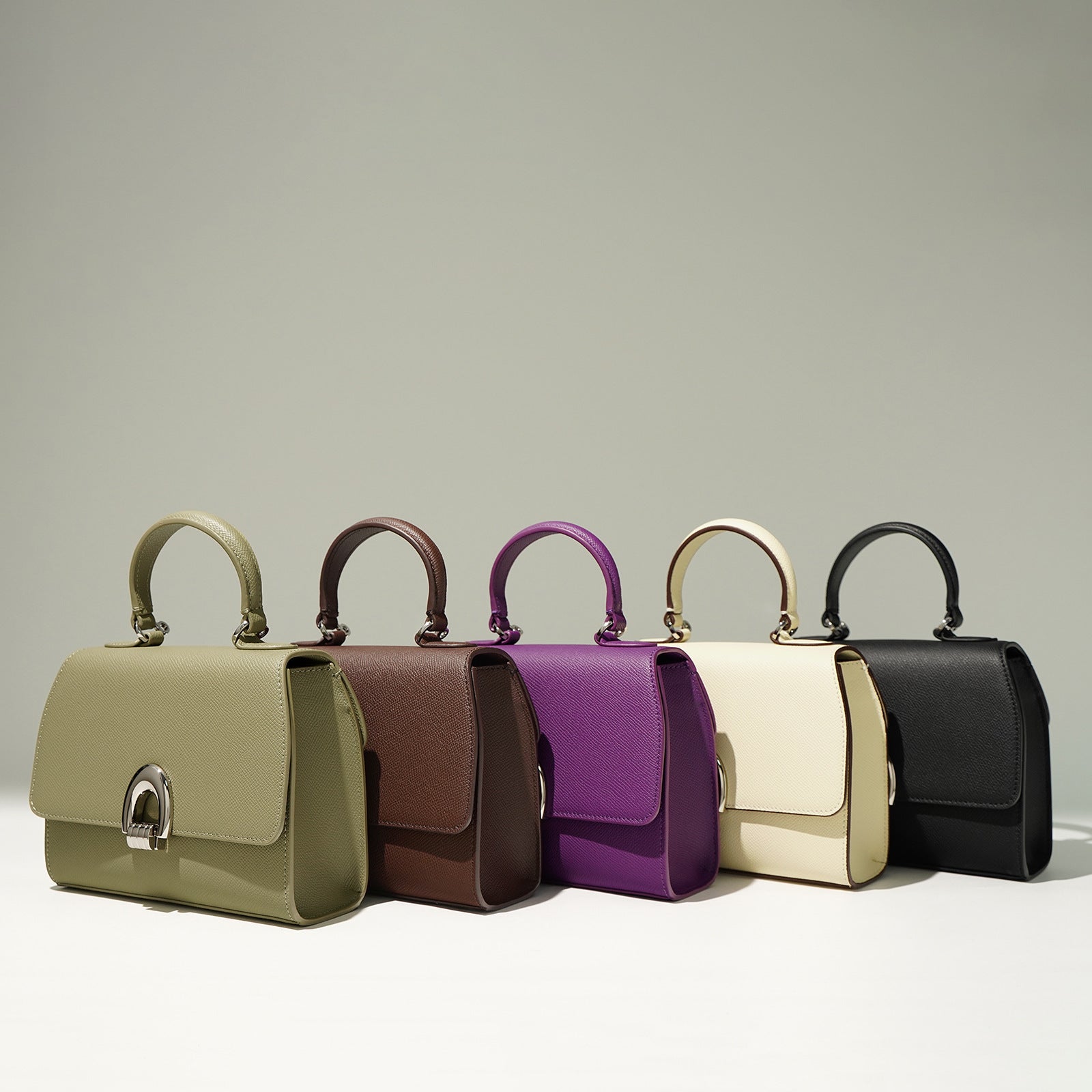 Showcasing of variety of colors of genuine leather bags in green, black, brown, white/ivory and purple.