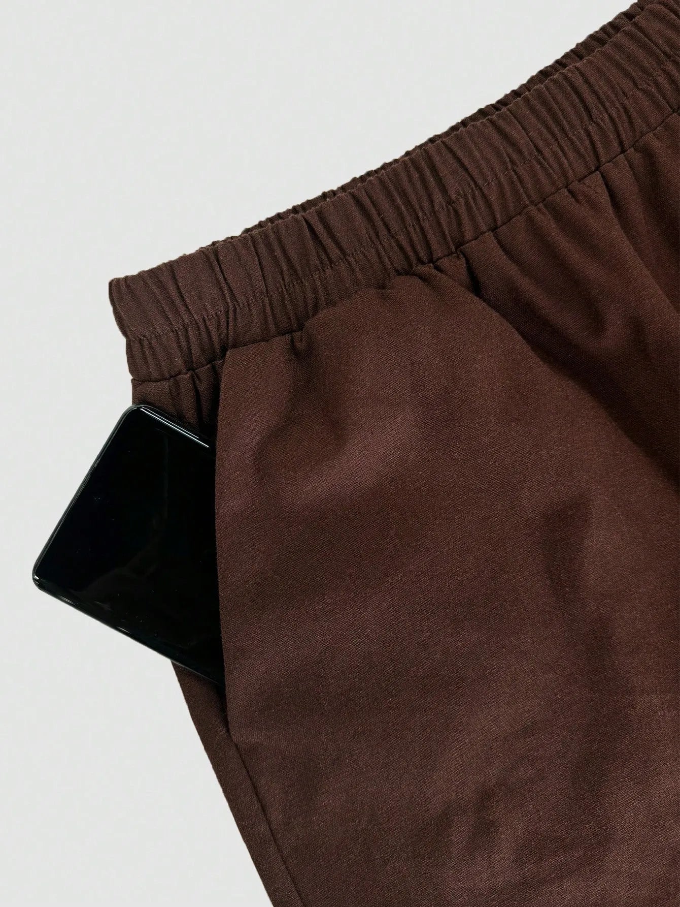 Brown pants with an elastic waistband on a light white background
