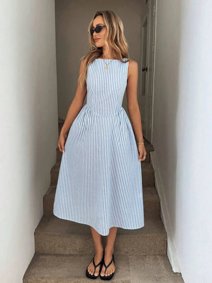 Woman wearing a blue and white striped casual midi dress standing in a hallway.