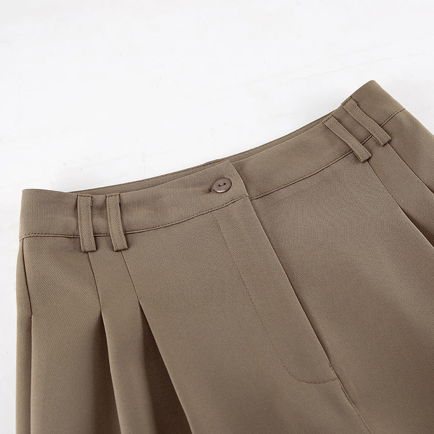 Close-up of brown tailored high wasit pants with a white background
