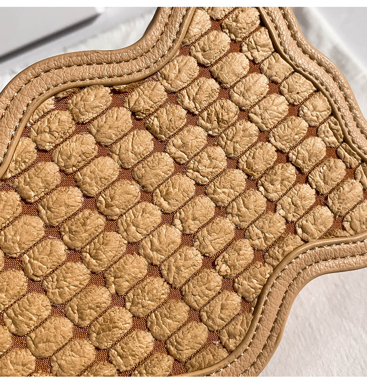 Close-up of a textured beige small Woven Wave Pattern Bag on a white background