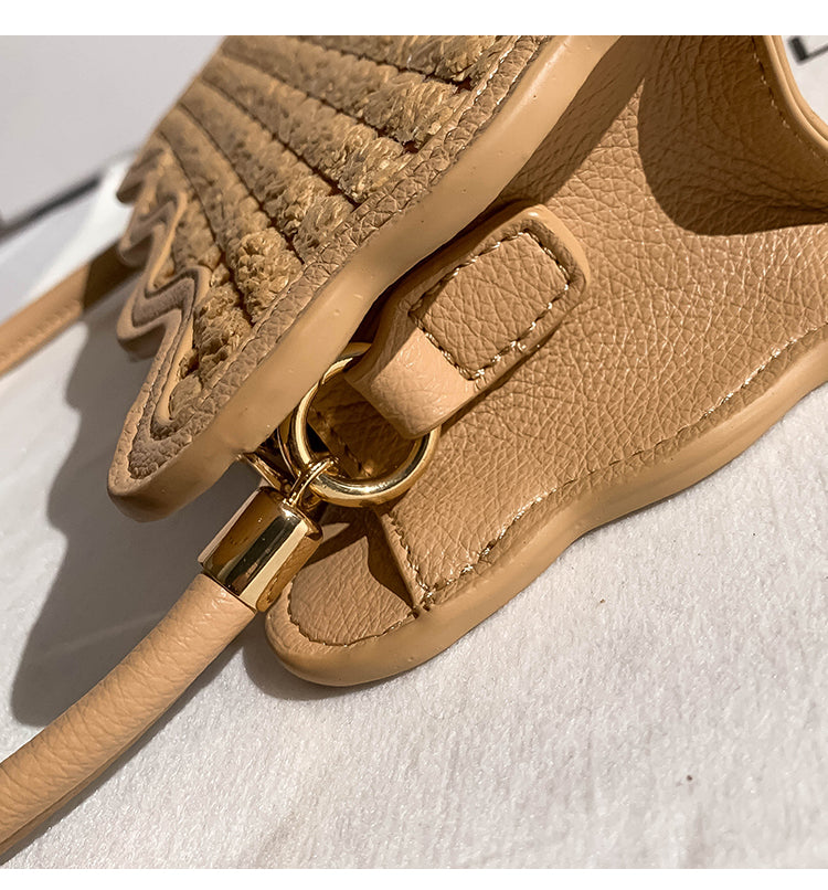 Close-up of a beige  leather handbag with a gold clasp on a light background