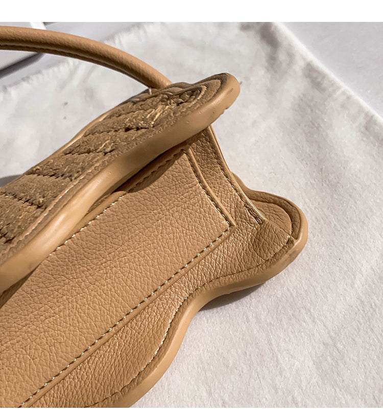 Close-up of beige woven wave pattern small bag