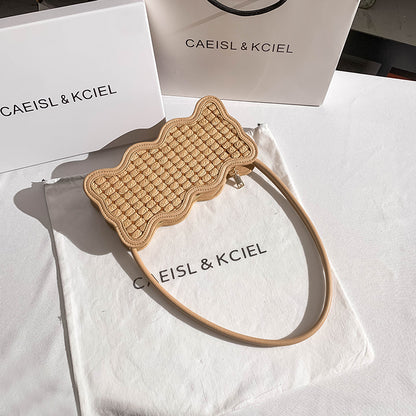 Beige woven headband on a white surface with 'CAEISL & KCIEL' branding.