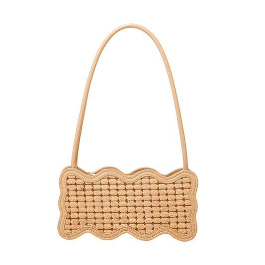 Beige woven handbag with a scalloped edge on a white background