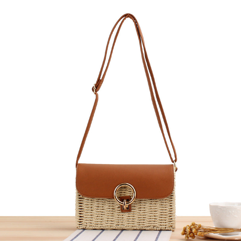 Woven Straw handbag with a brown leather flap and strap on a white background