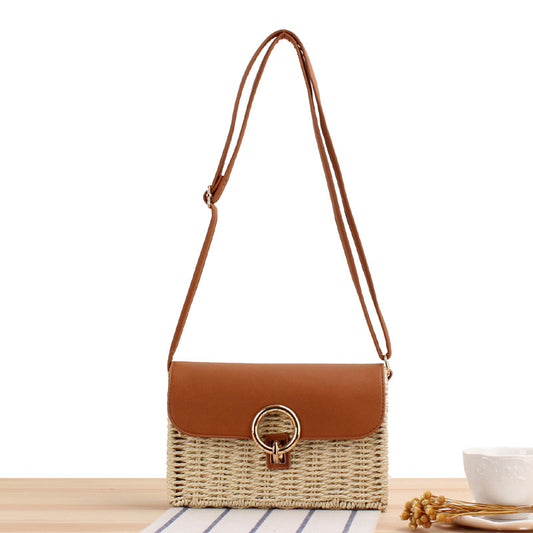 Woven Straw handbag with a brown leather flap and strap on a white background