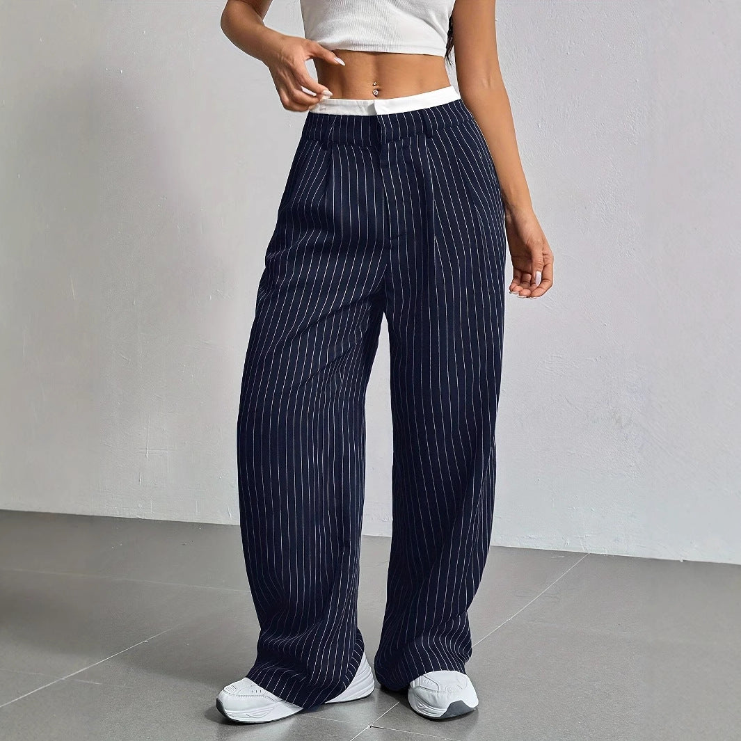 Woman wearing navy pinstripe pants with a white background