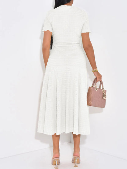 Back view of woman wearing a white ribbed stretched midi dress with short sleeves holding a handbag on a white background