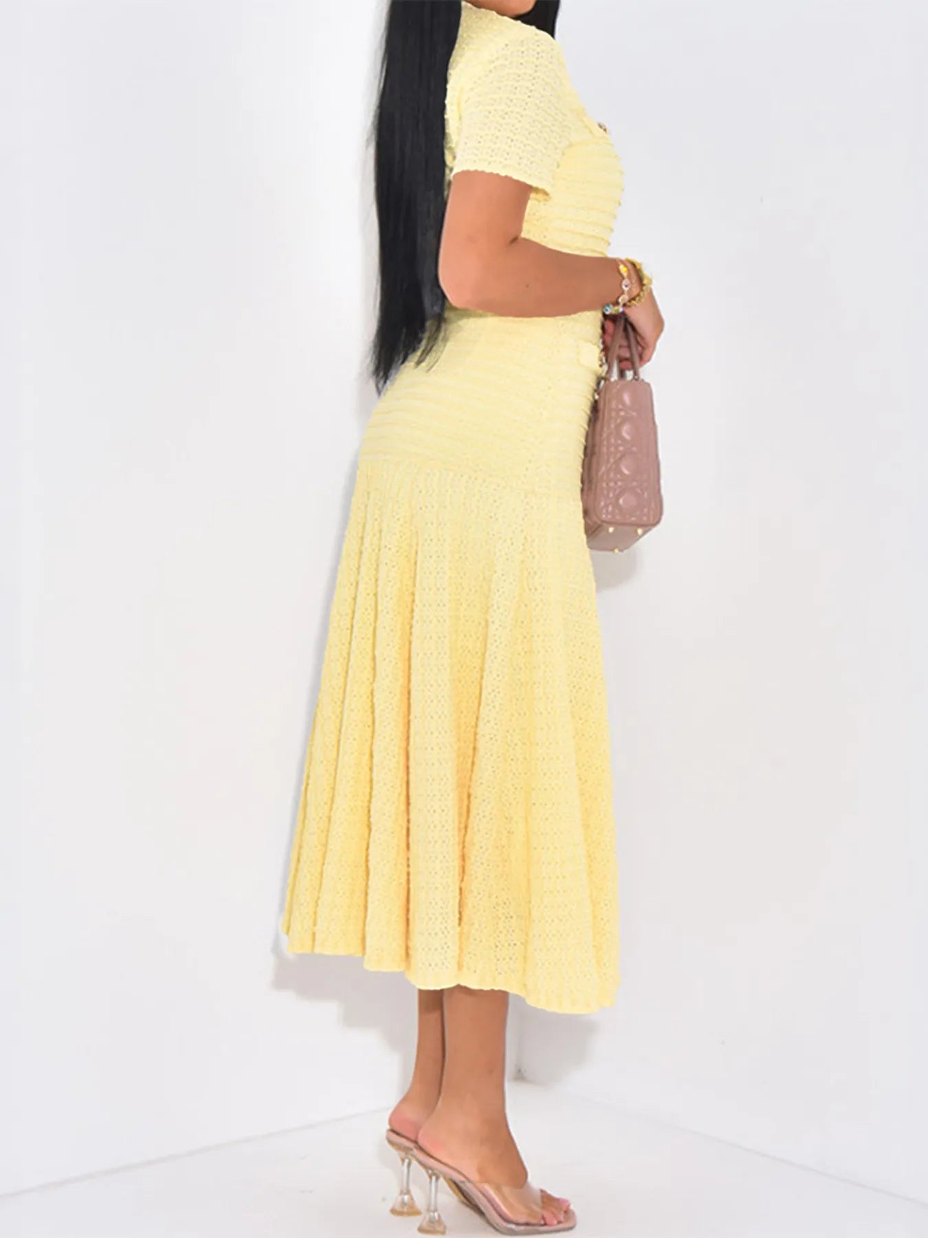 Side view of Woman wearing a butter yellow knit textured midi short sleeve dress on a plain white background