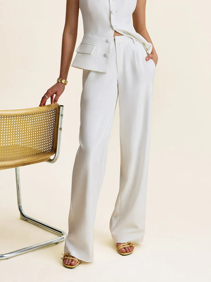 woman wearing a white suit with wide-leg pants on a beige background