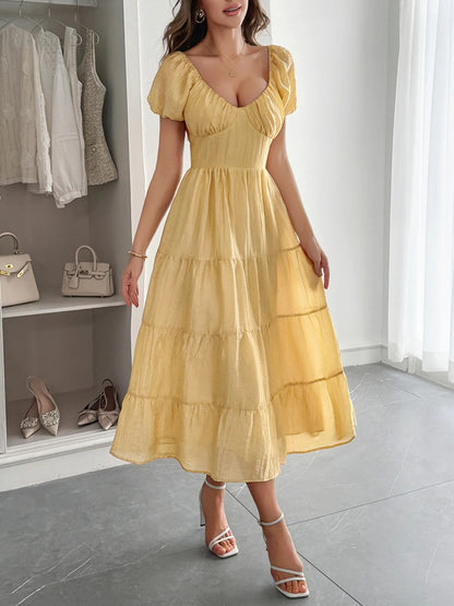 Woman wearing a yellow V-Neck summer Midi Dress with Short Sleeves in a room with shelves and shoes.