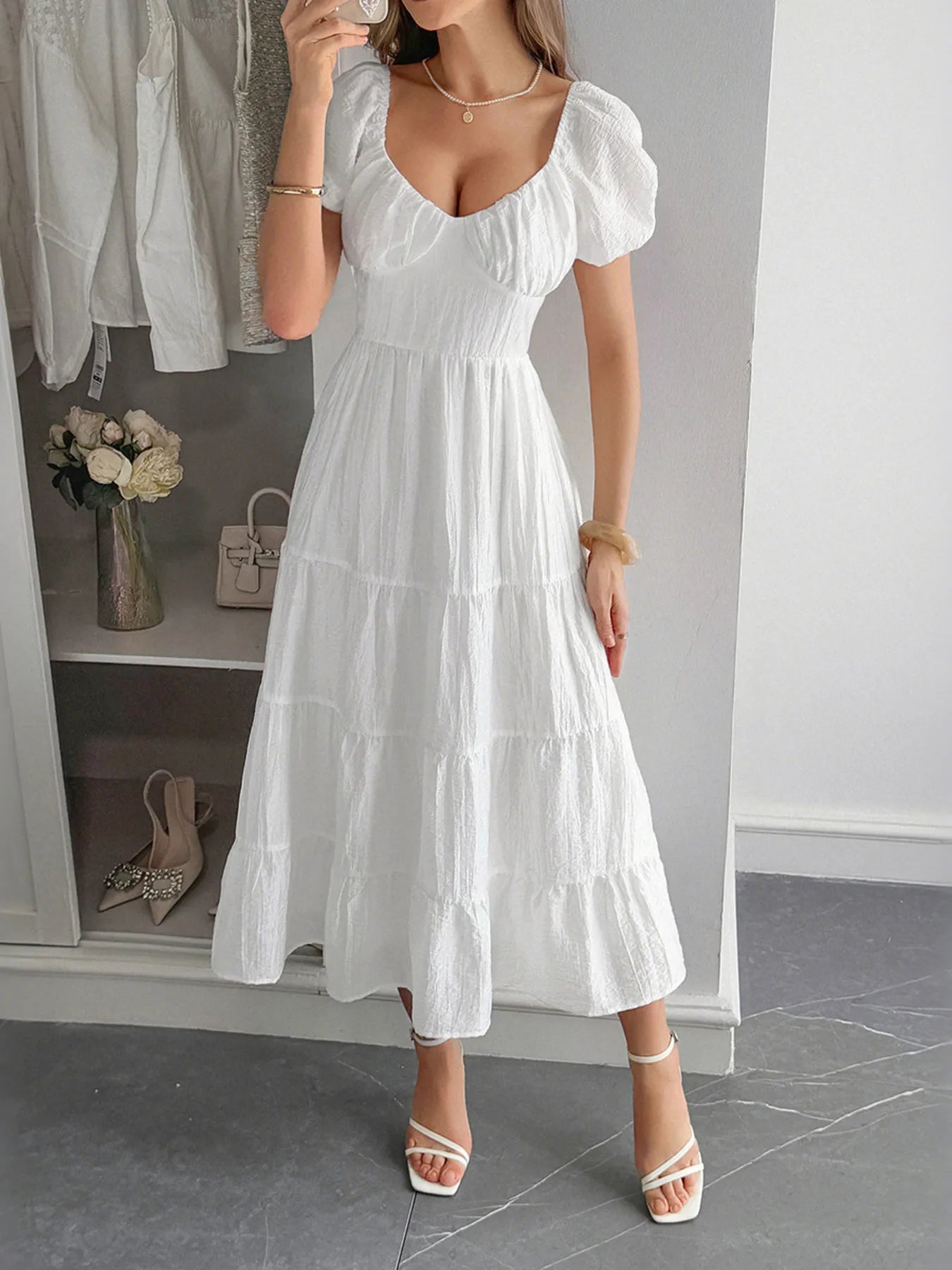 Woman wearing a white V-Neck backless summer Midi Dress with Short Sleeves in a room with a wardrobe and shoes.