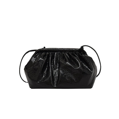 A metallic black colored  PU leather clip shell bag with detachable strap.
