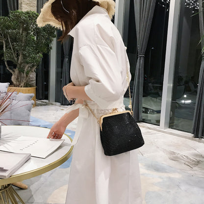 Woman wearing black rhinestone evening bag with gold pearl chain strap crossbody style