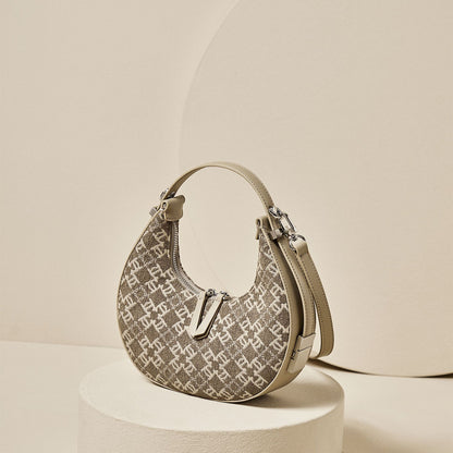 A beige woolen  monogram canvas crescent handbag displayed against a neutral background.