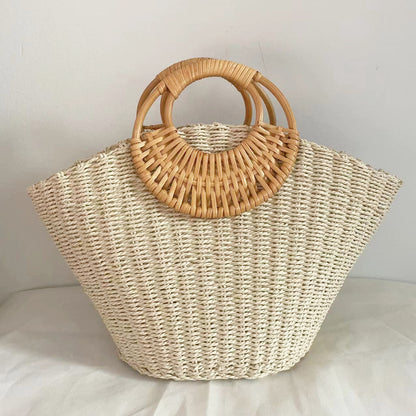 Woven straw handbag with wooden handles on a light background