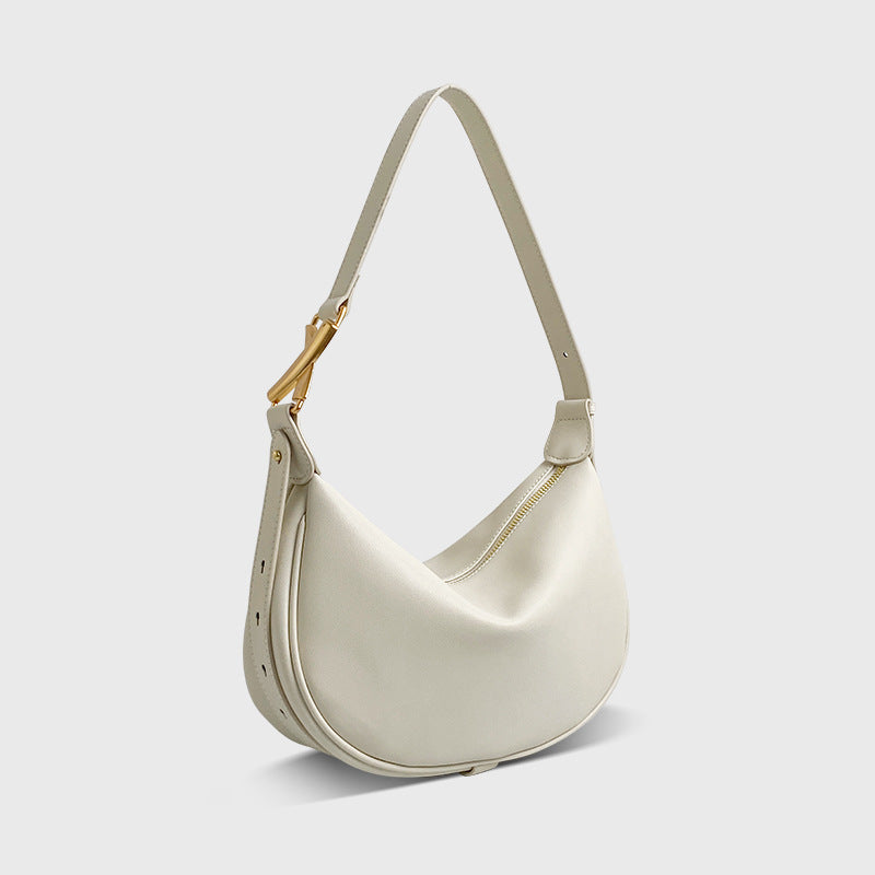 A white crescent-shaped genuine leather handbag with an adjustable strap and a zipper top closure.