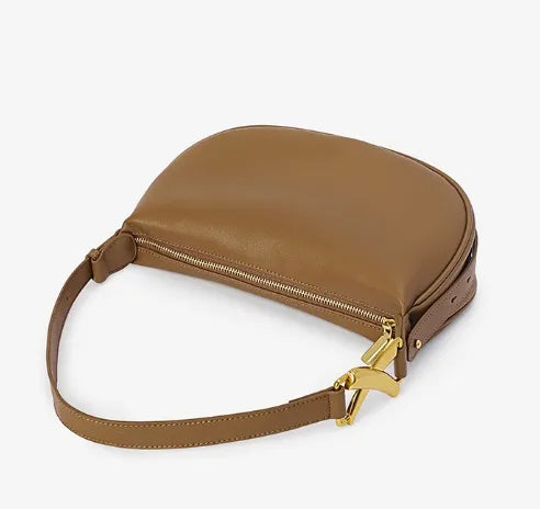Flat view of brown genuine leather bag with gold hardware on a white background