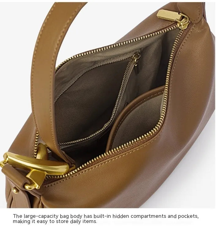 Brown genuine leather bag with gold zippers showing interior compartments.