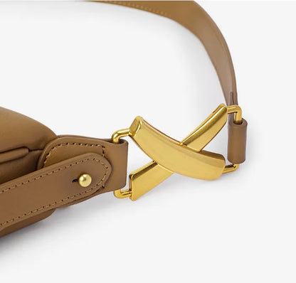 Close-up of a brown genuine leather bag with gold metal detail on a white background.