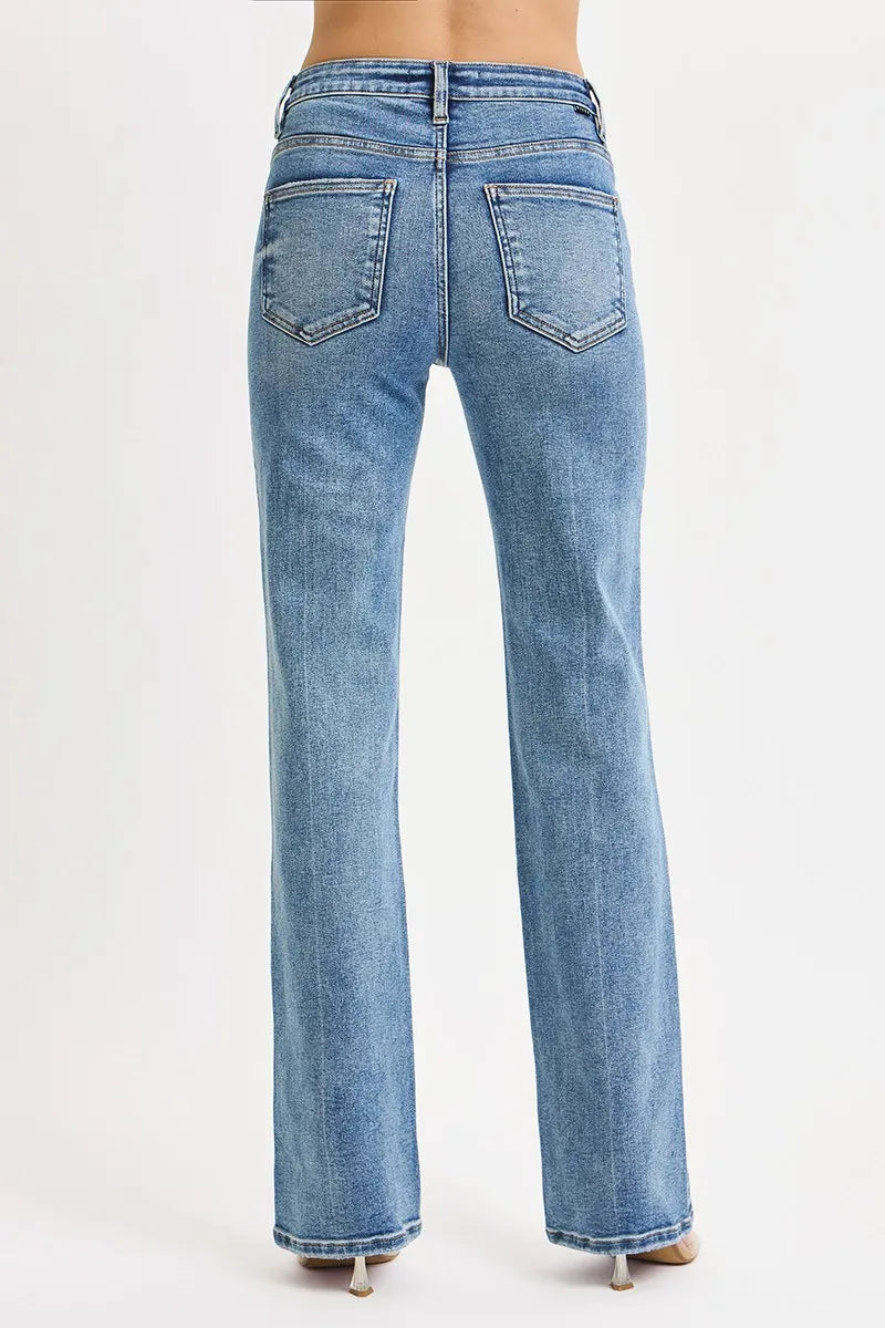 back view of woman wearing medium wash blue high rise tummy control straight leg jeans on a white background