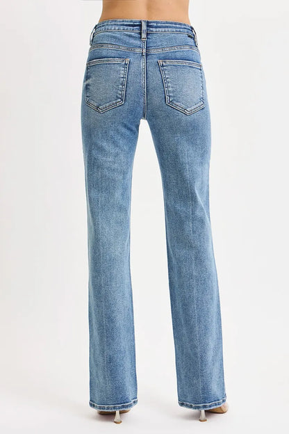 back view of woman wearing medium wash blue high rise tummy control straight leg jeans on a white background