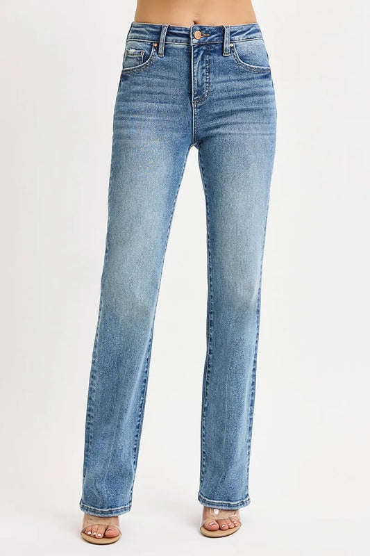 Front view of woman wearing medium wash blue high rise tummy control straight leg jeans on a white background
