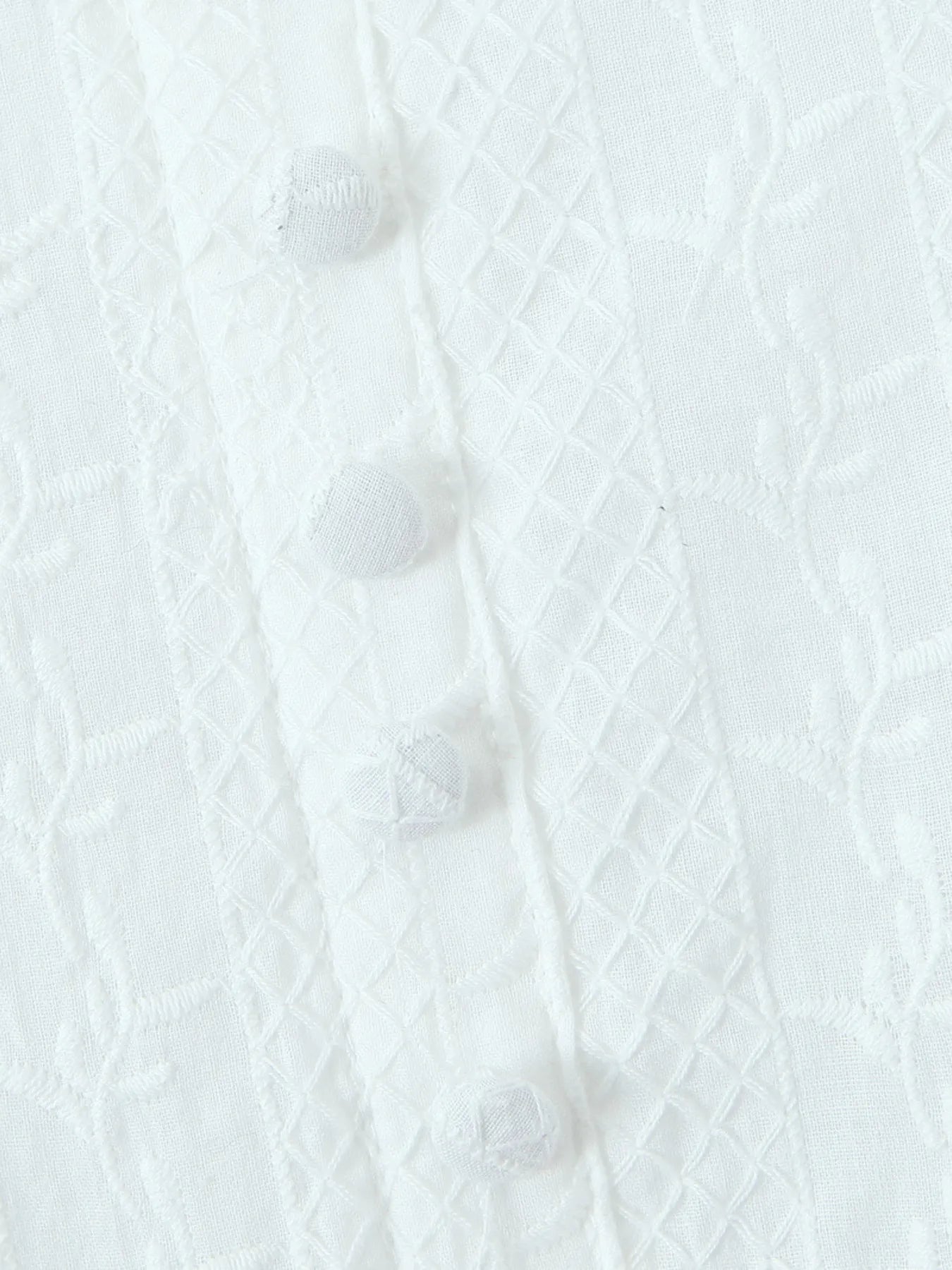 Close-up of lace mini dress in white front buttons and fabric texture 